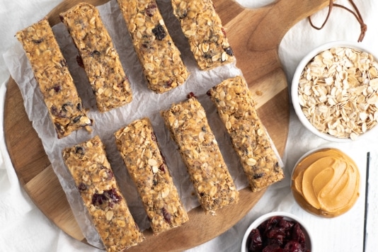 Plate of homemade easy granola energy bars with cranberries, peanut butter and oats in the corner Kitchen Cents