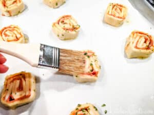 Brush pizza pinwheels with garlic butter | Kitchen Cents