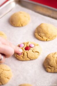 Placing M&Ms in par baked peanut butter cookies | Kitchen Cents