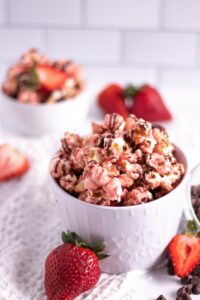 chocolate to this gourmet pink popcorn for a fun chocolate dipped strawberries vibe. Recipe shared by Kitchen Cents.
