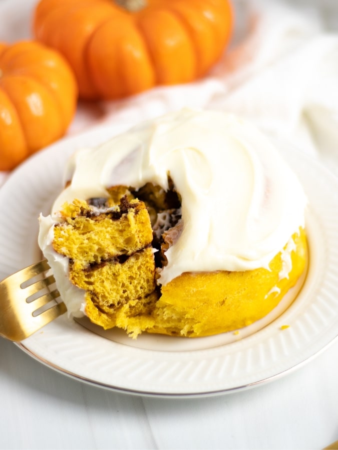 Frosted pumpkin roll with one bite on fork