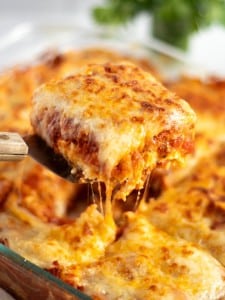 A slice of easy lasagna recipe being served from the baking dish